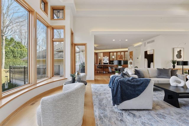 living area featuring recessed lighting, visible vents, baseboards, and wood finished floors