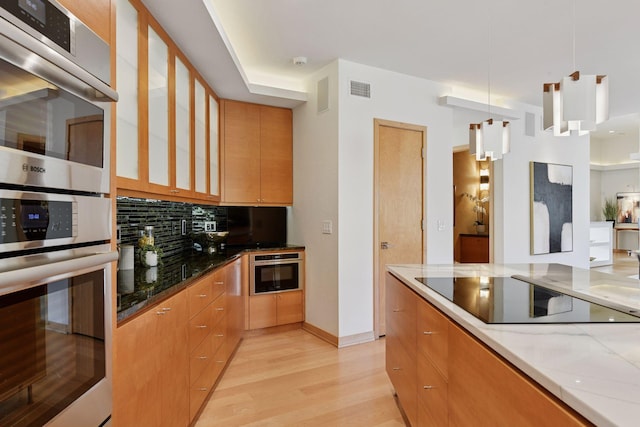 kitchen with black electric cooktop, light wood-type flooring, tasteful backsplash, modern cabinets, and glass insert cabinets