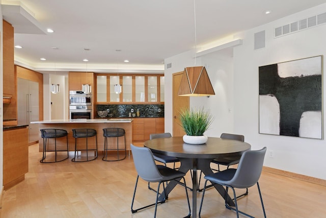 dining room with light wood-type flooring, visible vents, and recessed lighting