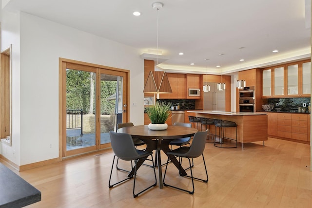 dining space featuring recessed lighting, baseboards, and light wood finished floors