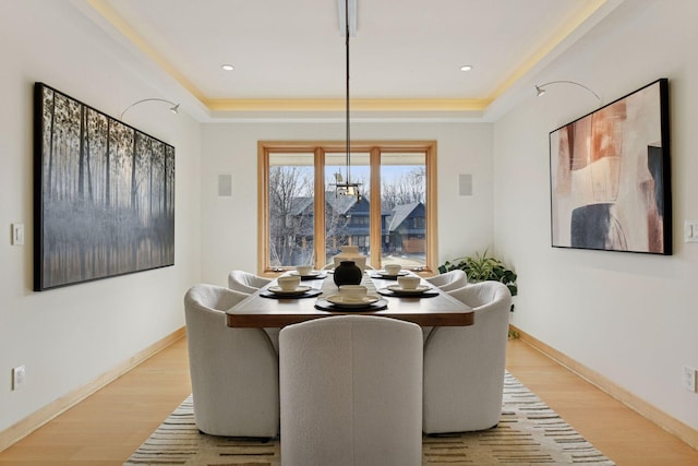 dining space with light wood finished floors, baseboards, and a notable chandelier