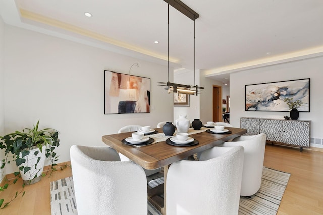 dining room featuring baseboards, wood finished floors, and recessed lighting