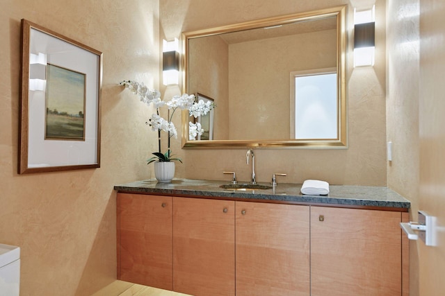 bathroom featuring a textured wall and vanity