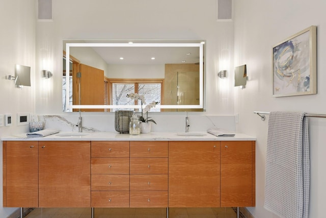 full bath with double vanity, a sink, and a walk in shower