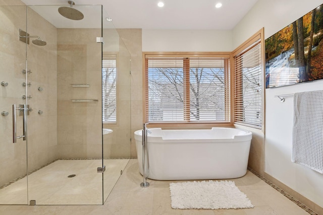 bathroom featuring a stall shower, a soaking tub, tile patterned flooring, and recessed lighting