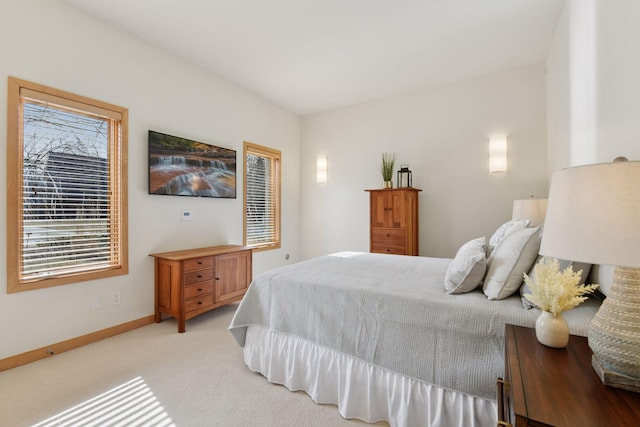 bedroom featuring light colored carpet and baseboards