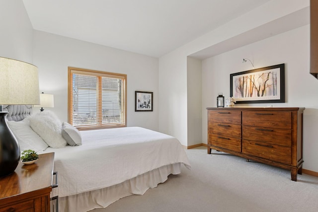 bedroom with light carpet and baseboards