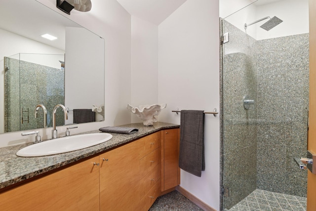 bathroom featuring a shower stall, baseboards, and vanity