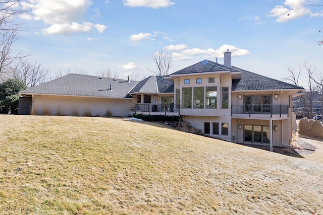 back of property featuring a yard, a chimney, and stucco siding