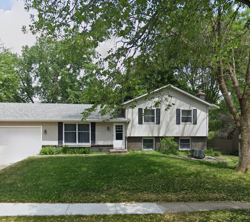 split level home featuring a garage and a front lawn