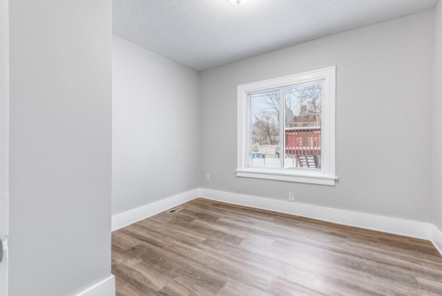 spare room with hardwood / wood-style floors and a textured ceiling