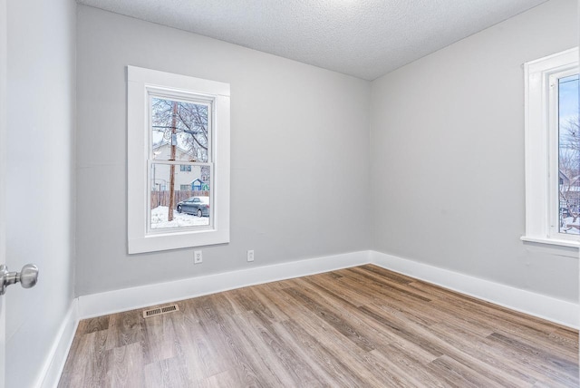 empty room featuring hardwood / wood-style flooring and a textured ceiling