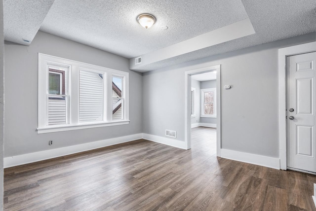 spare room featuring dark hardwood / wood-style floors and a textured ceiling