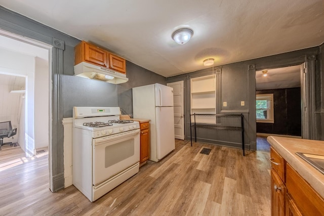 kitchen with white appliances and light hardwood / wood-style floors