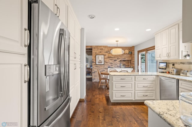 kitchen featuring stainless steel appliances, white cabinets, and decorative light fixtures