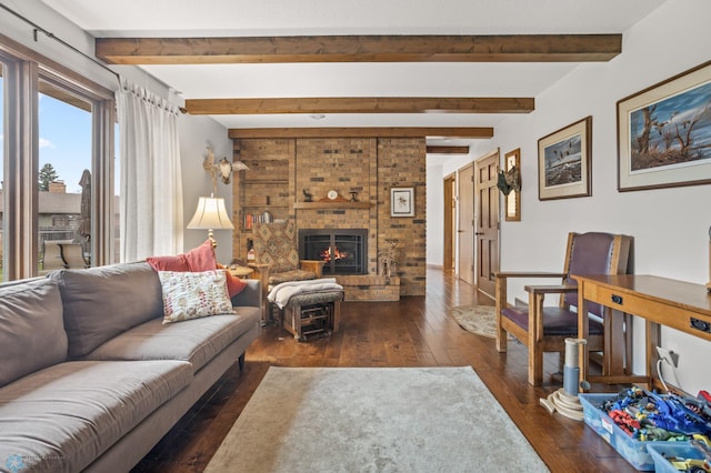 living room with beamed ceiling, dark hardwood / wood-style floors, and a brick fireplace