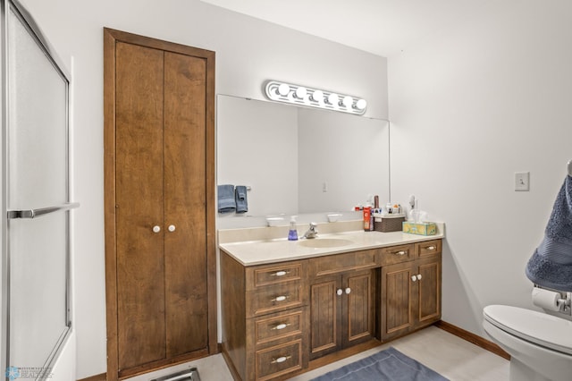 bathroom with vanity, toilet, and a shower with door