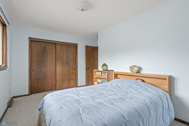 bedroom featuring light carpet, a baseboard radiator, and a closet