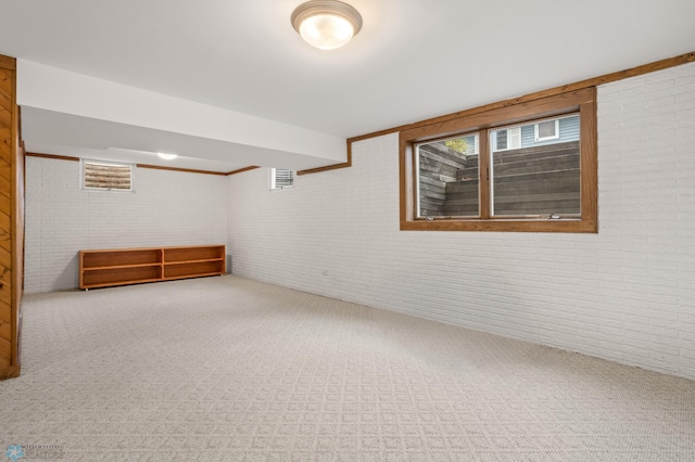 interior space featuring carpet and brick wall