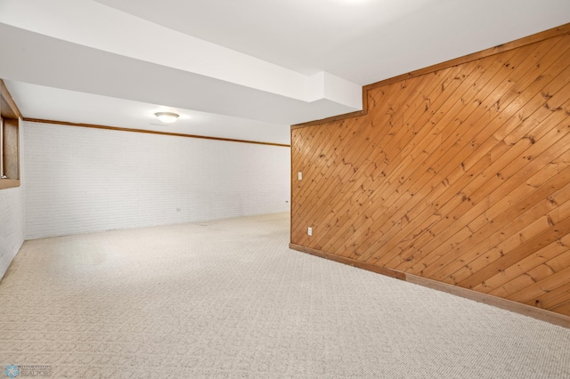 basement featuring carpet flooring, brick wall, and wood walls