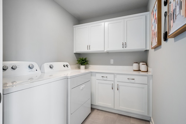 clothes washing area with washing machine and dryer and cabinets