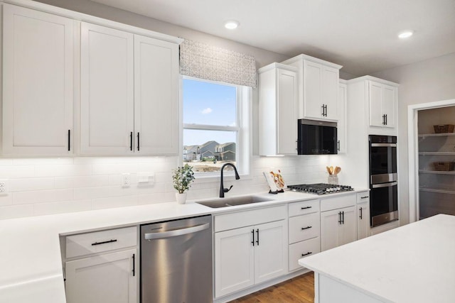 1691 Oak Creek Ct, Chaska, MN 55318 - kitchen with stainless steel appliances, a sink, decorative backsplash, white cabinetry, and recessed lighting