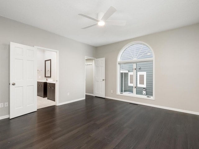 unfurnished bedroom featuring dark wood-type flooring, ceiling fan, and connected bathroom