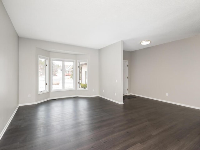 unfurnished room with dark wood-type flooring