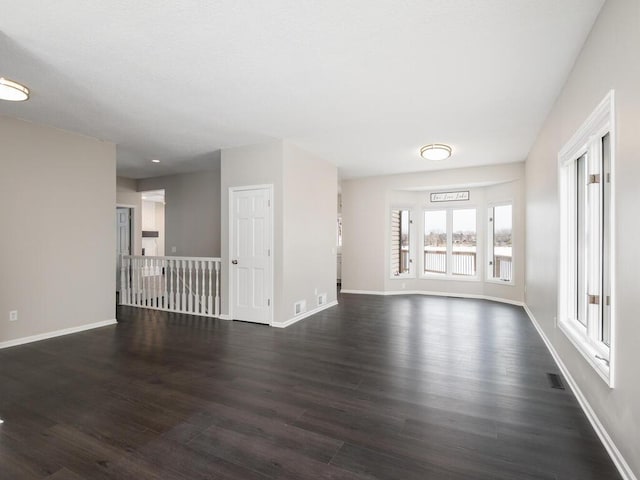 unfurnished living room with dark wood-type flooring