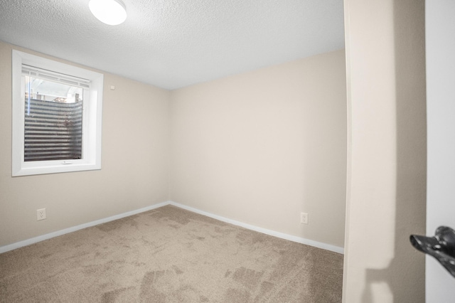 unfurnished room featuring carpet and a textured ceiling