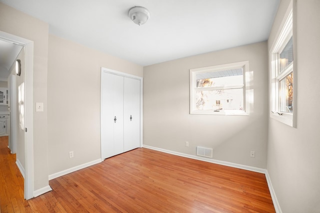 unfurnished bedroom featuring light hardwood / wood-style floors and a closet