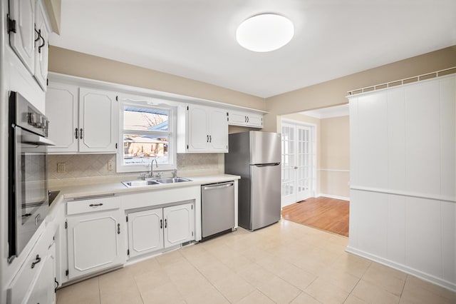 kitchen featuring white cabinetry, appliances with stainless steel finishes, sink, and decorative backsplash