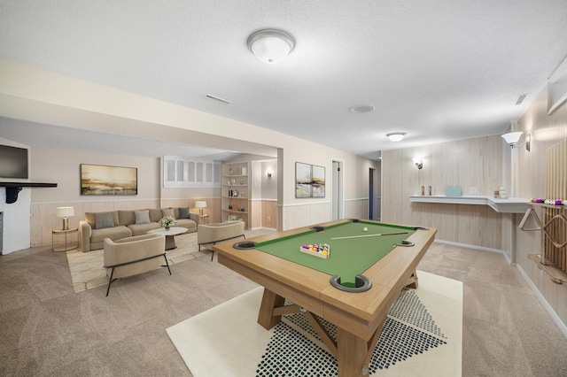 rec room featuring light colored carpet, wooden walls, billiards, and a textured ceiling