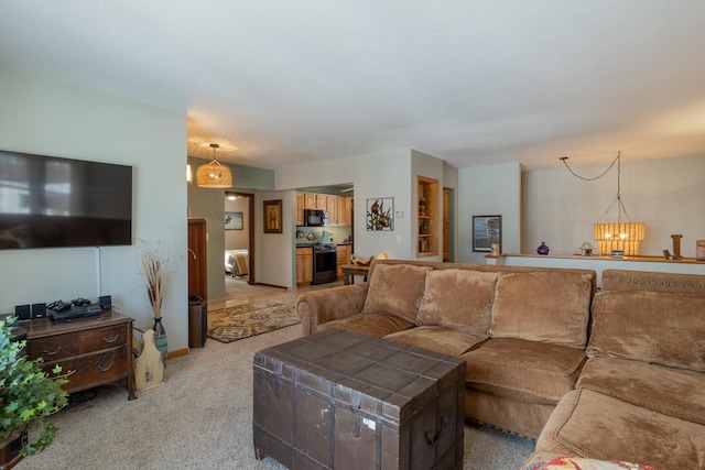 living area featuring baseboards, an inviting chandelier, and light colored carpet