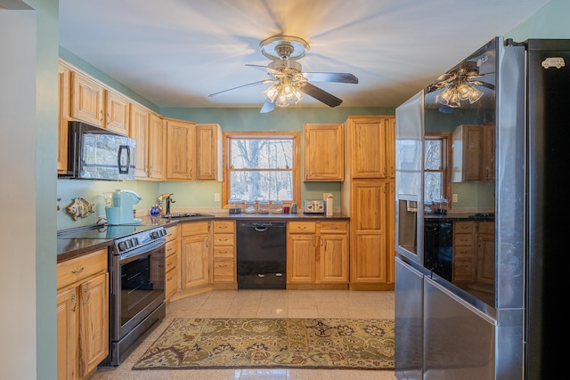 kitchen featuring dark countertops, ceiling fan, black appliances, light brown cabinets, and a sink