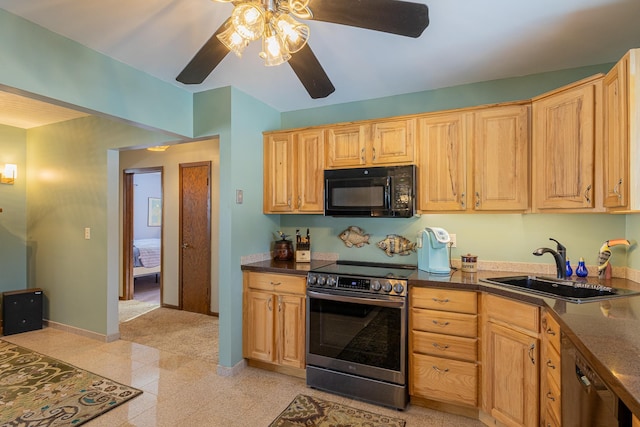 kitchen with dark countertops, black appliances, baseboards, and a sink