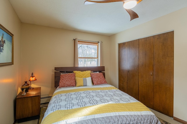 bedroom with ceiling fan, a textured ceiling, baseboard heating, and a closet