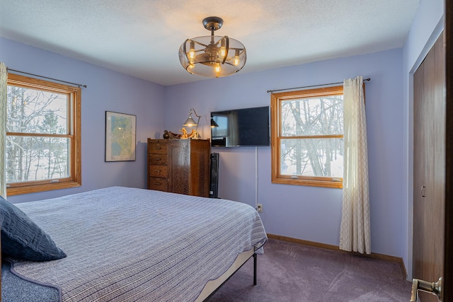 bedroom featuring carpet flooring, a textured ceiling, and baseboards