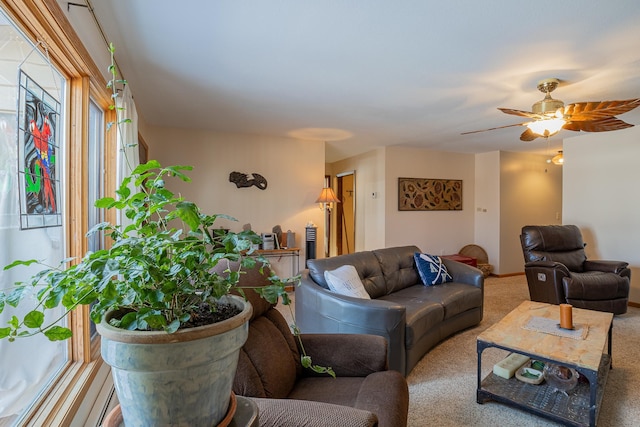 carpeted living room featuring a ceiling fan and baseboards