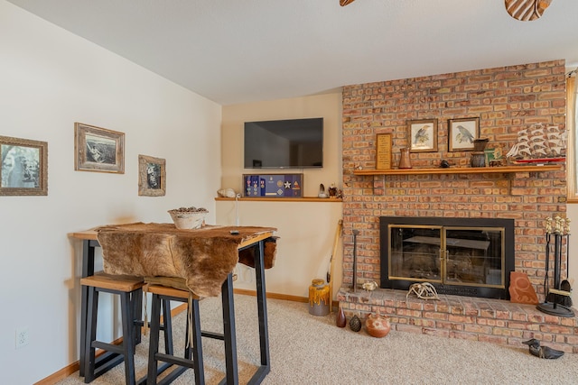 living area featuring carpet, a fireplace, and baseboards