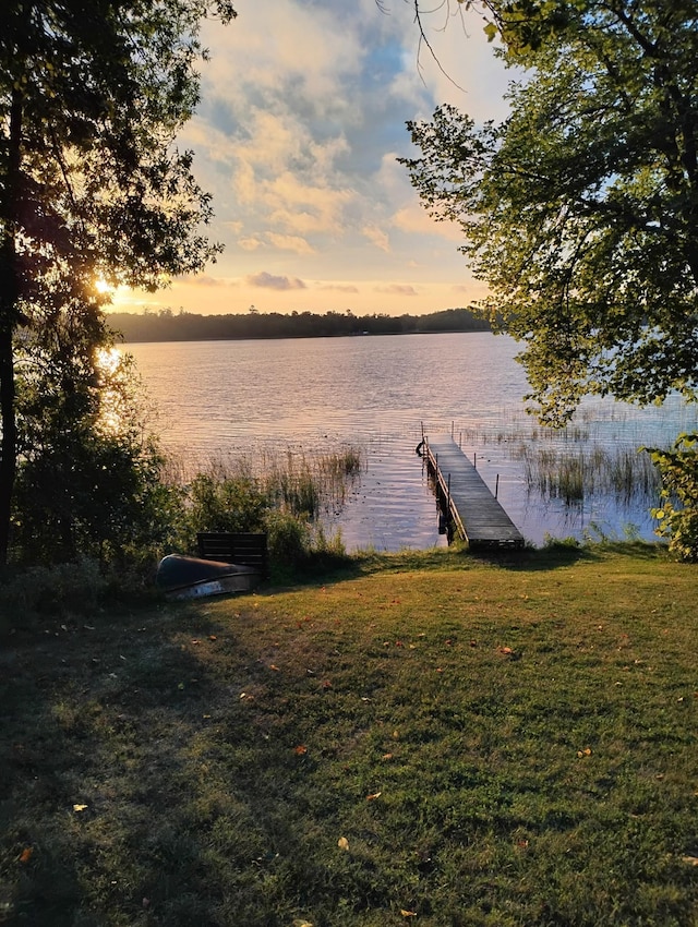 dock area featuring a water view and a lawn