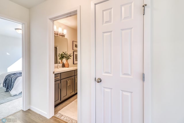 hallway featuring sink and light hardwood / wood-style flooring