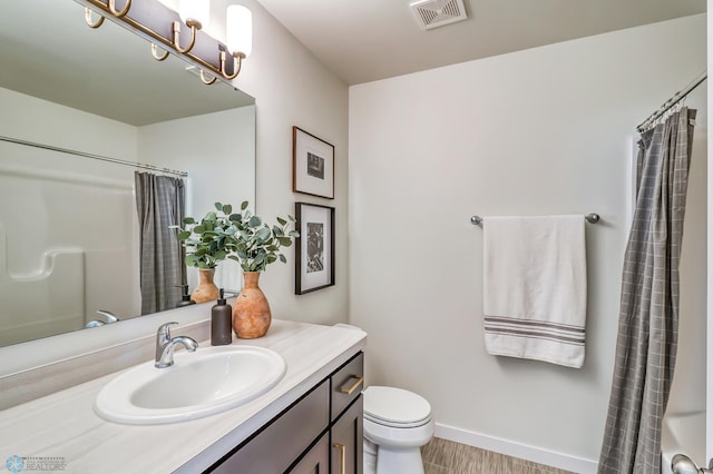 bathroom with vanity, a notable chandelier, hardwood / wood-style flooring, and toilet