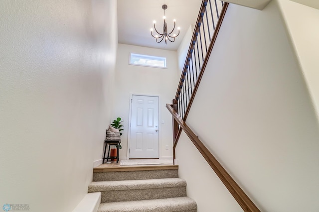 stairs with a towering ceiling and a notable chandelier