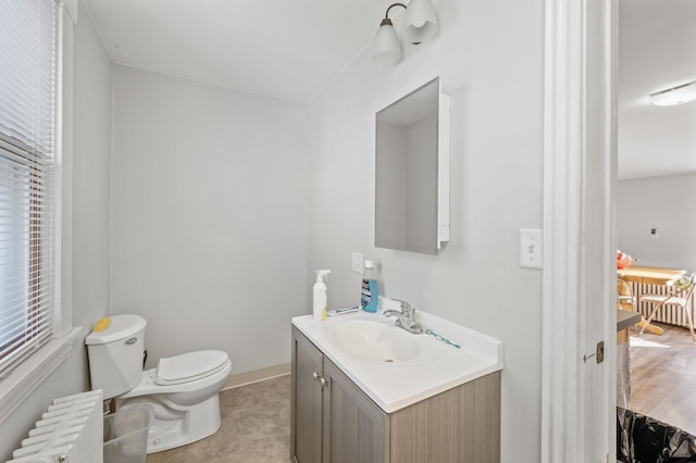 bathroom with vanity, radiator heating unit, and toilet