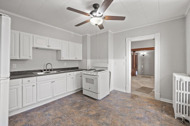 kitchen with white appliances, radiator heating unit, sink, and white cabinets