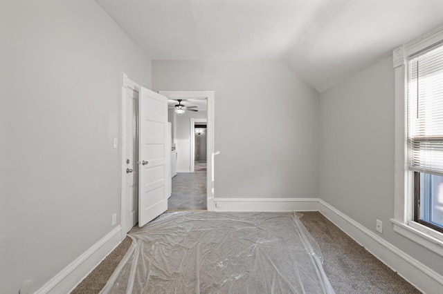 unfurnished bedroom with vaulted ceiling and carpet flooring