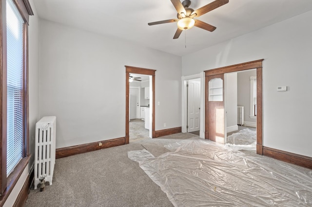 carpeted bedroom with ceiling fan, radiator heating unit, and ensuite bath