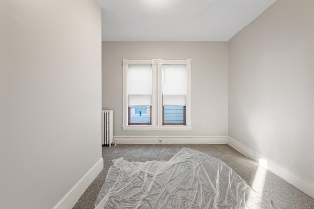 carpeted empty room featuring radiator