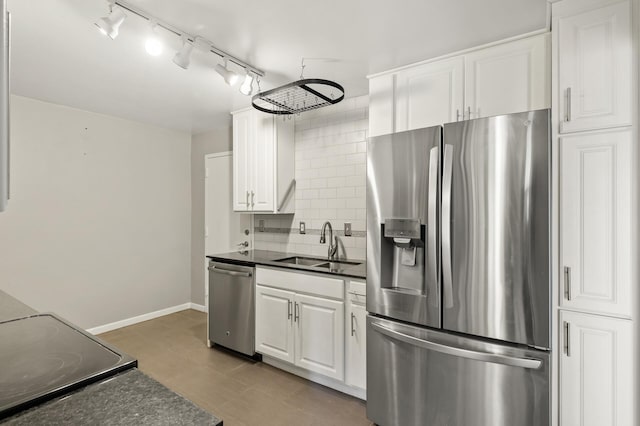 kitchen with tasteful backsplash, sink, white cabinets, and appliances with stainless steel finishes